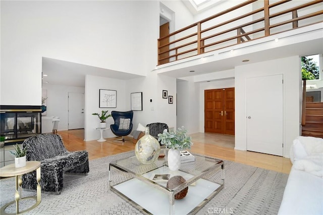 828 Wonder View Dr, Calabasas, CA 91302 - living area with wood finished floors, a towering ceiling, and a skylight
