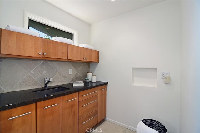 828 Wonder View Dr, Calabasas, CA 91302 - kitchen featuring brown cabinetry, backsplash, dark stone countertops, and light tile patterned floors