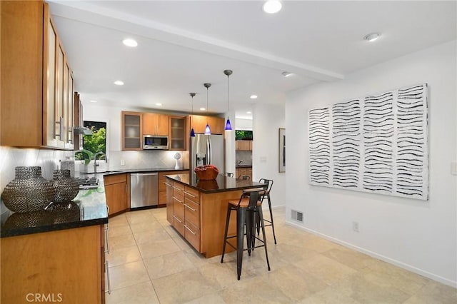 828 Wonder View Dr, Calabasas, CA 91302 - kitchen featuring stainless steel appliances, a kitchen breakfast bar, brown cabinetry, backsplash, and a center island