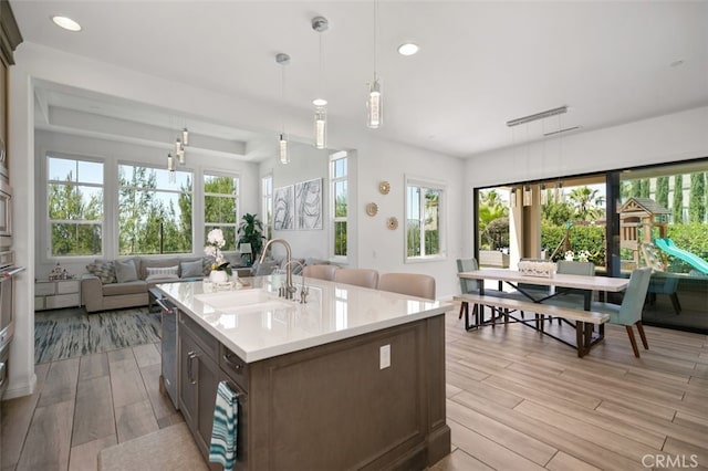 11 Juniper, Lake Forest, CA 92630 - kitchen featuring light wood-type flooring, open floor plan, light countertops, hanging light fixtures, and recessed lighting