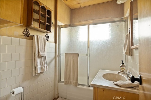 32953 Juniper Ln, Green Valley Lake, CA 92341 - bathroom featuring plenty of natural light, combined bath / shower with glass door, vanity, and tile walls
