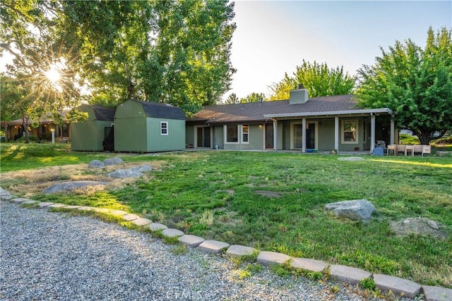 24050 Basin Harbor Ct, Tehachapi, CA 93561 - back of property featuring a storage shed, a chimney, and a lawn