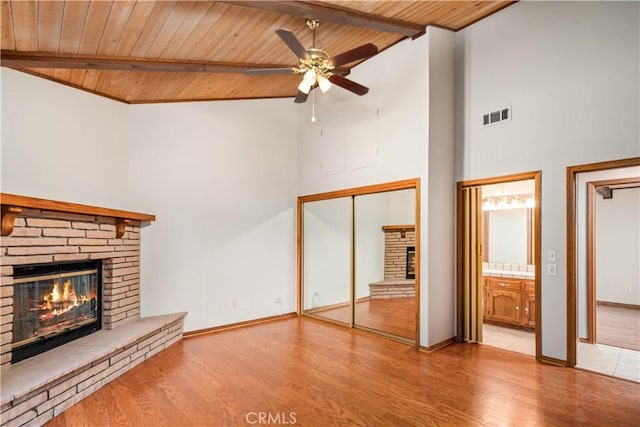 24050 Basin Harbor Ct, Tehachapi, CA 93561 - unfurnished living room with a stone fireplace, a wood ceiling with exposed beams, a ceiling fan, high vaulted ceiling, and wood finished floors