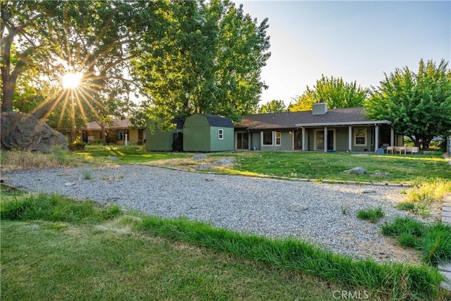24050 Basin Harbor Ct, Tehachapi, CA 93561 - rear view of house with a storage unit, a yard, and a chimney