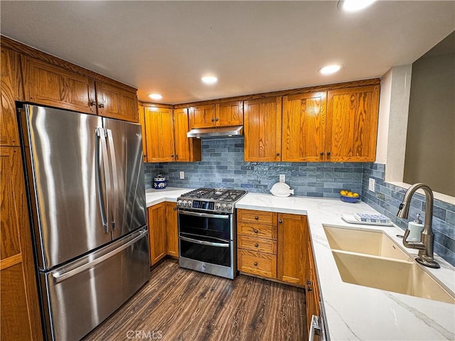 18602 Creek Ln, Huntington Beach, CA 92648 - kitchen featuring stainless steel appliances, under cabinet range hood, dark wood-style flooring, brown cabinets, and decorative backsplash