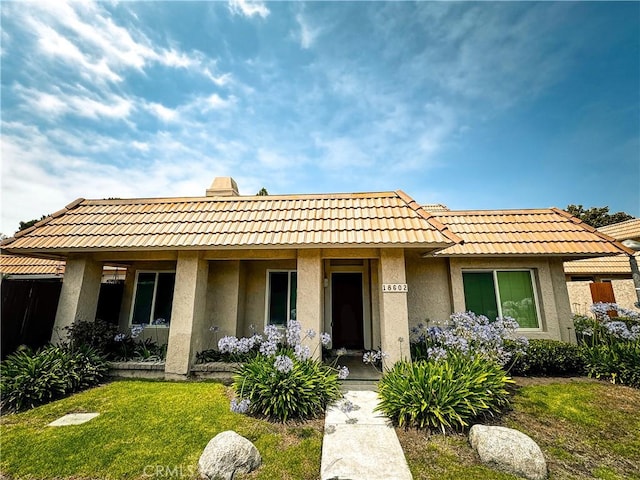 18602 Creek Ln, Huntington Beach, CA 92648 - view of front facade with stucco siding, a tile roof, and a front yard