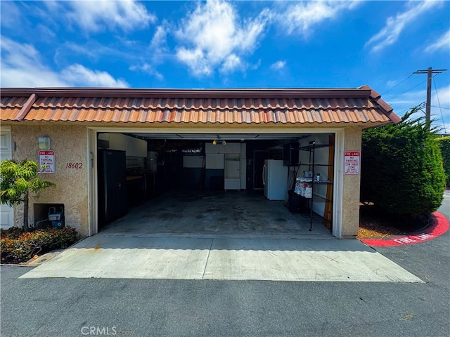 18602 Creek Ln, Huntington Beach, CA 92648 - garage featuring freestanding refrigerator and driveway