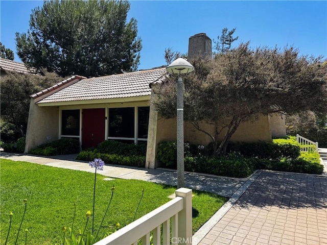 18602 Creek Ln, Huntington Beach, CA 92648 - view of front of home with a front lawn, stucco siding, a tiled roof, and a chimney