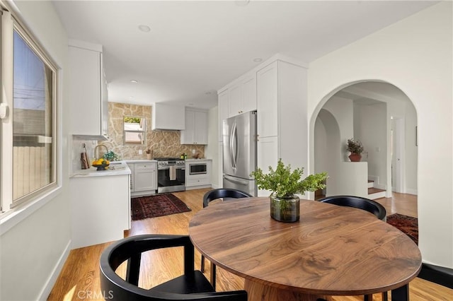 4131 Edgehill Dr, Los Angeles, CA 90008 - dining room featuring light wood-style floors and arched walkways