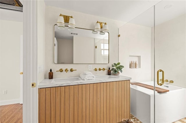 4131 Edgehill Dr, Los Angeles, CA 90008 - bathroom featuring double vanity, a soaking tub, and wood finished floors