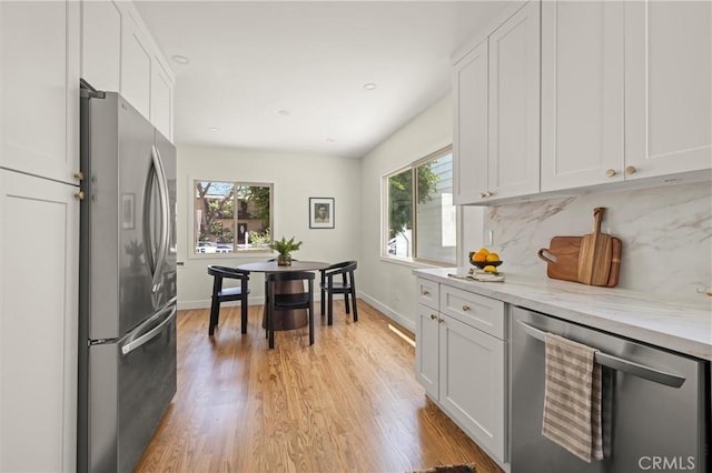 4131 Edgehill Dr, Los Angeles, CA 90008 - kitchen featuring appliances with stainless steel finishes, white cabinets, light wood-style floors, tasteful backsplash, and recessed lighting