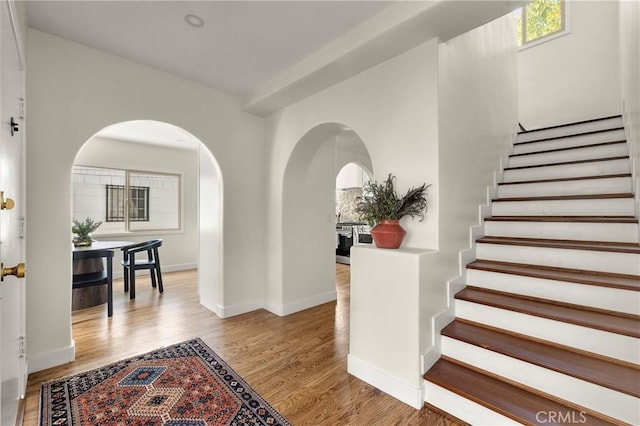 4131 Edgehill Dr, Los Angeles, CA 90008 - foyer with arched walkways, stairs, and wood finished floors