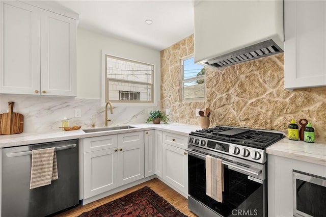 4131 Edgehill Dr, Los Angeles, CA 90008 - kitchen with appliances with stainless steel finishes, custom exhaust hood, wood finished floors, and white cabinetry