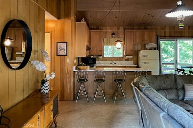 22908 Redwood Way, Crestline, CA 92325 - kitchen featuring refrigerator, wooden ceiling, open floor plan, wood walls, and black microwave