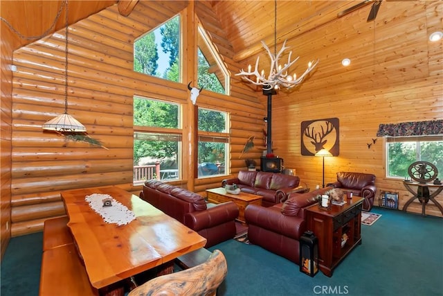 29729 Katherine Way, Cedar Glen, CA 92321 - carpeted living room featuring a towering ceiling, a chandelier, rustic walls, and a wood stove