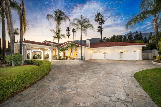 275 E 24th St, Upland, CA 91784 - mediterranean / spanish-style house featuring concrete driveway, stucco siding, a garage, a tiled roof, and a chimney