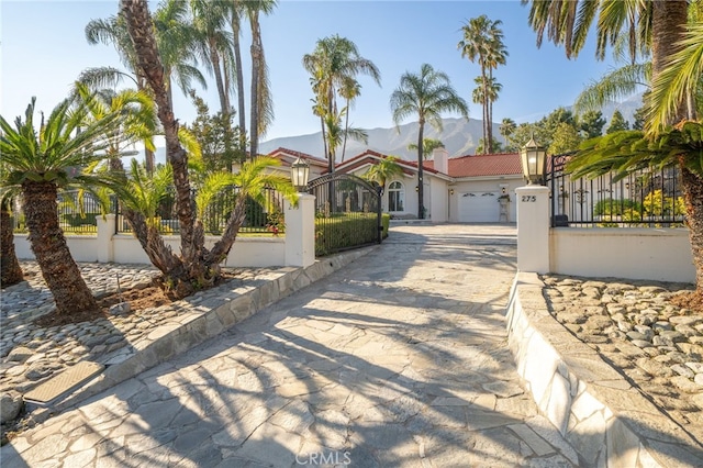 275 E 24th St, Upland, CA 91784 - mediterranean / spanish house with concrete driveway, a fenced front yard, stucco siding, and an attached garage