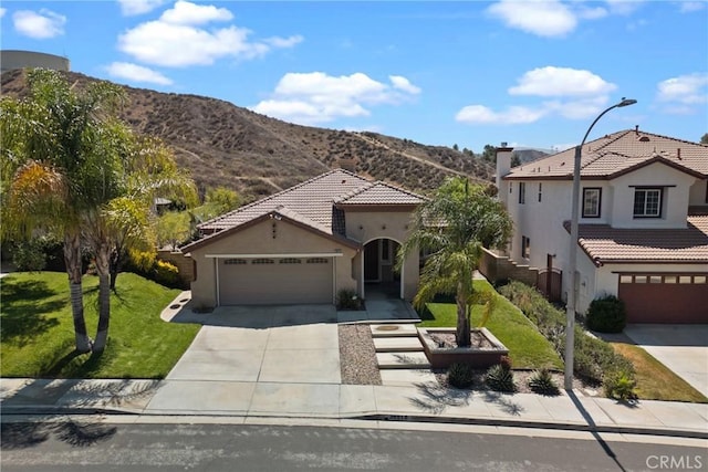 28518 High Ridge Dr, Saugus, CA 91390 - mediterranean / spanish house with concrete driveway, stucco siding, a front yard, and a mountain view
