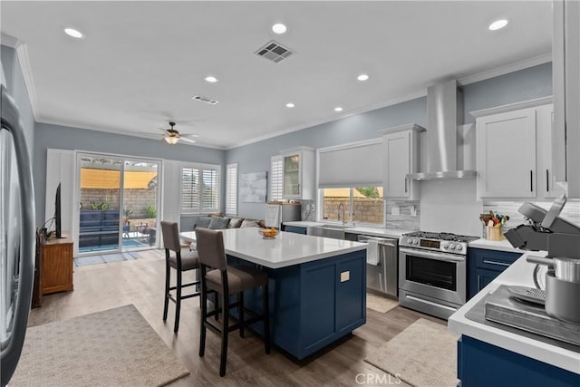 28518 High Ridge Dr, Saugus, CA 91390 - kitchen featuring wall chimney range hood, appliances with stainless steel finishes, a center island, light countertops, and crown molding