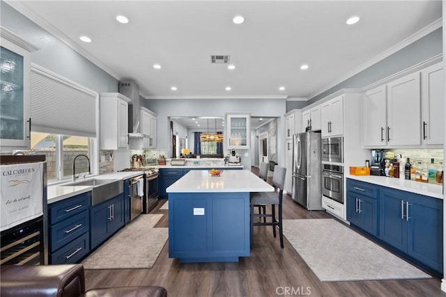 28518 High Ridge Dr, Saugus, CA 91390 - kitchen with appliances with stainless steel finishes, a center island, a kitchen breakfast bar, blue cabinets, and recessed lighting