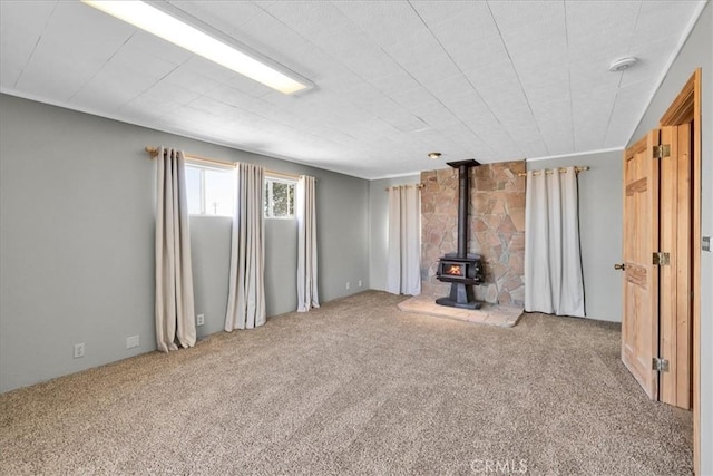 1638 Hales Dr Unit 29, Palms, CA 92277 - unfurnished living room with a wood stove and carpet floors