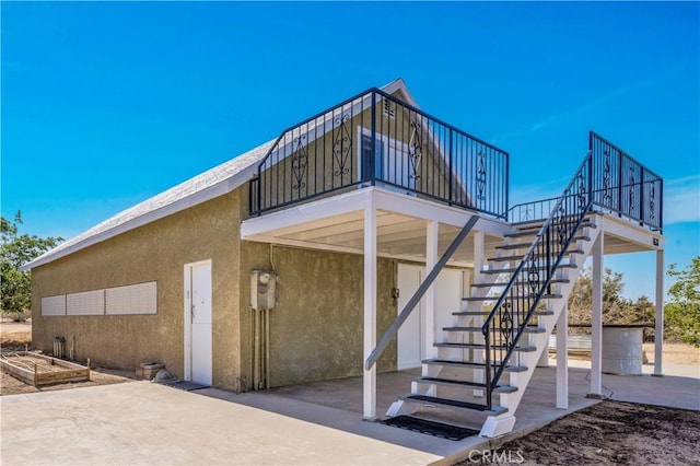 1638 Hales Dr Unit 29, Palms, CA 92277 - back of house with stairway, stucco siding, and a patio