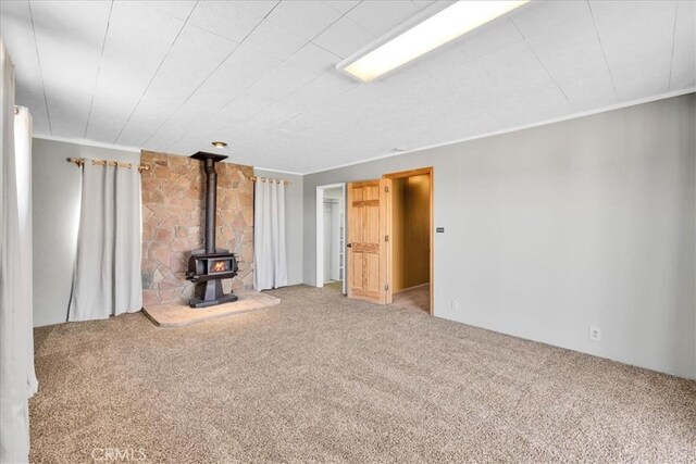 1638 Hales Dr Unit 29, Palms, CA 92277 - unfurnished living room with carpet floors and a wood stove