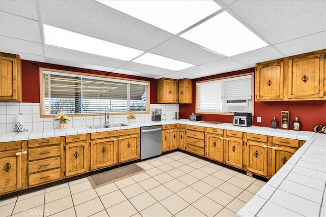 1638 Hales Dr Unit 29, Palms, CA 92277 - kitchen with stainless steel dishwasher, a drop ceiling, brown cabinets, and backsplash