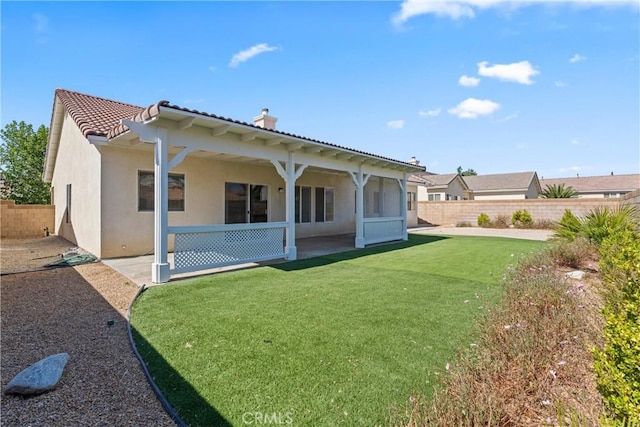 2041 Kalliope Ave, Lancaster, CA 93536 - back of property featuring stucco siding, a fenced backyard, a patio area, a tiled roof, and a chimney