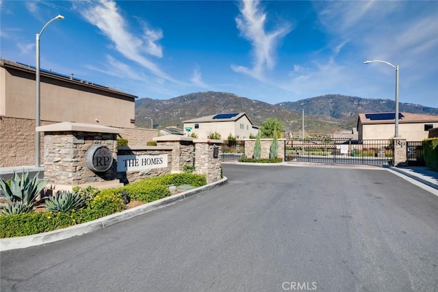 6425 N Cava Ln, San Bernardino, CA 92407 - view of asphalt street with a mountain view, street lights, a gate, and curbs