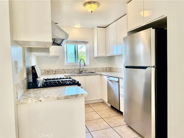 16115 Central Ave, La Puente, CA 91744 - kitchen with stainless steel appliances, wall chimney exhaust hood, white cabinets, and light tile patterned floors
