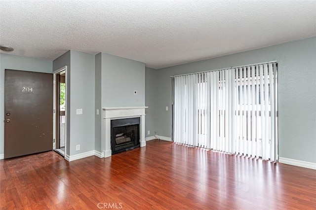 13100 Creek View Dr Unit 204, Garden Grove, CA 92844 - unfurnished living room featuring wood finished floors, a textured ceiling, and a fireplace