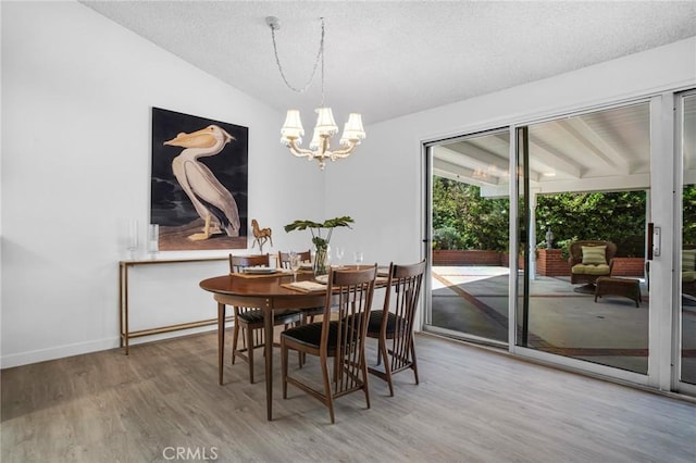 9545 Rubio Ave, Northridge, CA 91343 - dining area with a chandelier, wood finished floors, lofted ceiling, and a textured ceiling