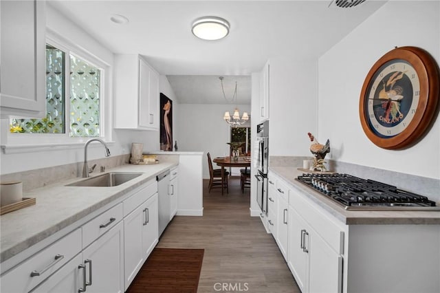 9545 Rubio Ave, Northridge, CA 91343 - kitchen with appliances with stainless steel finishes, light wood-type flooring, light countertops, and white cabinets