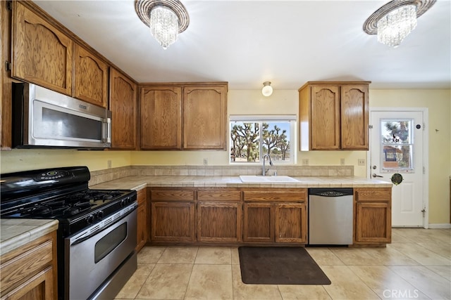 58706 Buena Vista Dr, Yucca Valley, CA 92284 - kitchen with appliances with stainless steel finishes, tile counters, a chandelier, and brown cabinetry