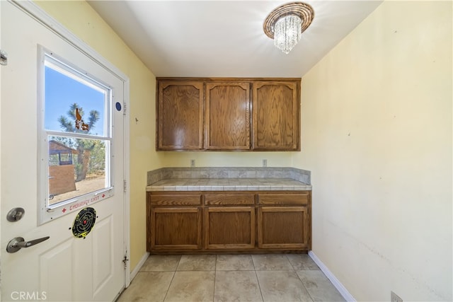 58706 Buena Vista Dr, Yucca Valley, CA 92284 - kitchen featuring brown cabinetry, light tile patterned floors, and tile counters