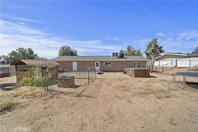 58706 Buena Vista Dr, Yucca Valley, CA 92284 - rear view of house featuring a hot tub, a trampoline, and a patio area