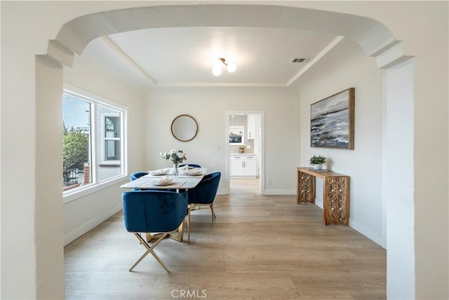 1818 W 79th St, Los Angeles, CA 90047 - dining space featuring arched walkways, light wood-type flooring, and crown molding