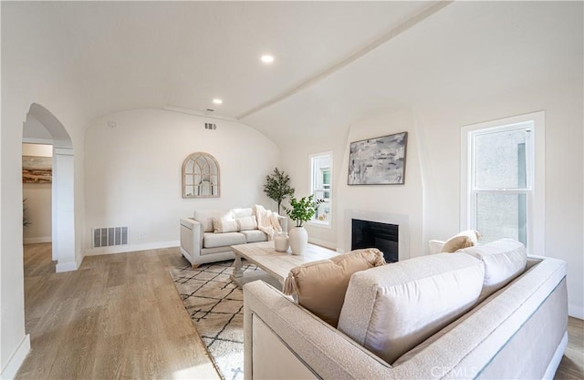 1818 W 79th St, Los Angeles, CA 90047 - living room with arched walkways, wood finished floors, a fireplace, recessed lighting, and lofted ceiling