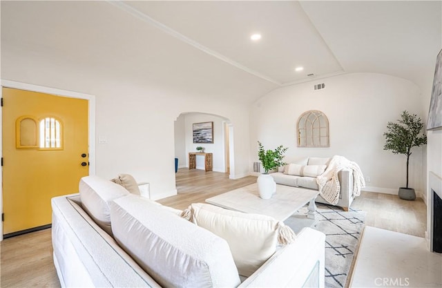 1818 W 79th St, Los Angeles, CA 90047 - living area with arched walkways, light wood-style floors, lofted ceiling, recessed lighting, and a fireplace