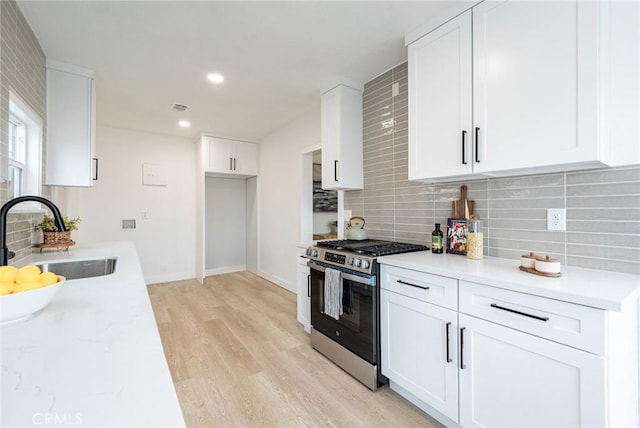 1818 W 79th St, Los Angeles, CA 90047 - kitchen with gas range, tasteful backsplash, light wood finished floors, white cabinetry, and recessed lighting