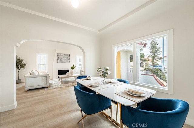 1818 W 79th St, Los Angeles, CA 90047 - dining room with arched walkways, a fireplace, wood finished floors, and crown molding