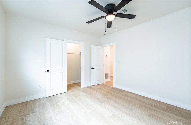 1818 W 79th St, Los Angeles, CA 90047 - unfurnished bedroom with light wood-style floors, a spacious closet, a closet, and a ceiling fan