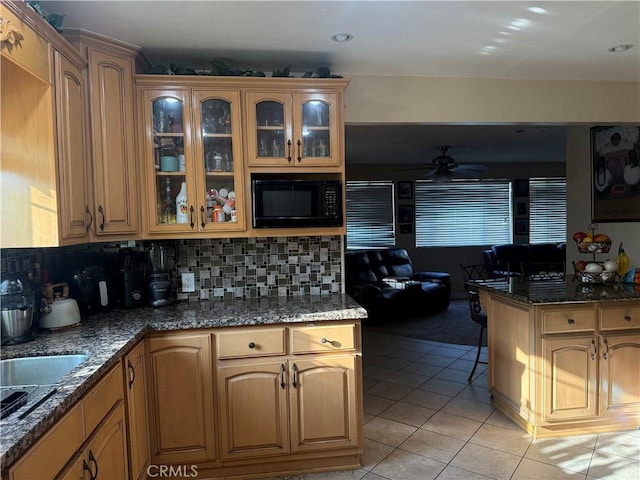6045 Lincoln Ave, South Gate, CA 90280 - kitchen featuring black microwave, light tile patterned floors, ceiling fan, tasteful backsplash, and glass insert cabinets