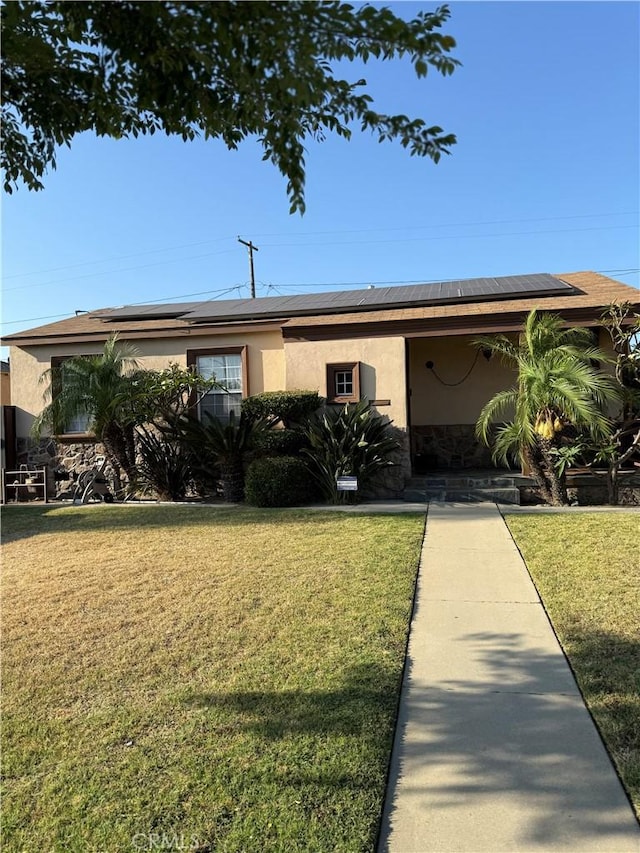 6045 Lincoln Ave, South Gate, CA 90280 - view of front facade with stucco siding, solar panels, and a front lawn