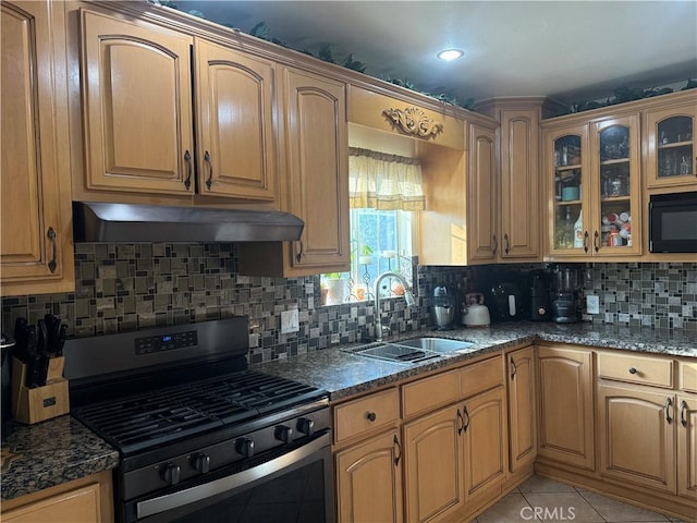 6045 Lincoln Ave, South Gate, CA 90280 - kitchen with gas stove, premium range hood, tasteful backsplash, glass insert cabinets, and dark stone counters