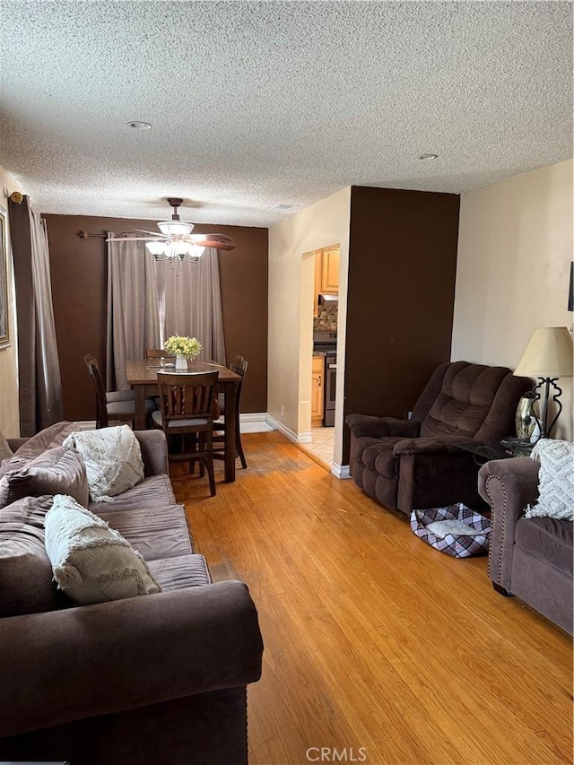 6045 Lincoln Ave, South Gate, CA 90280 - living room featuring a textured ceiling, ceiling fan, and light wood-style floors