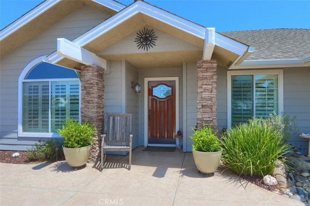 47003 Lookout Mountain Dr, Coarsegold, CA 93614 - doorway to property with a shingled roof, stone siding, and covered porch