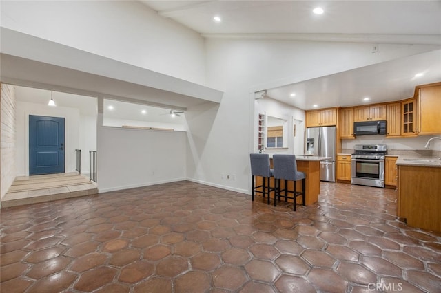 27403 Garza Dr, Saugus, CA 91350 - kitchen with stainless steel appliances, a breakfast bar, glass insert cabinets, light countertops, and recessed lighting
