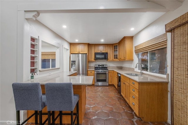 27403 Garza Dr, Saugus, CA 91350 - kitchen featuring stainless steel appliances, a peninsula, glass insert cabinets, a breakfast bar, and light stone countertops